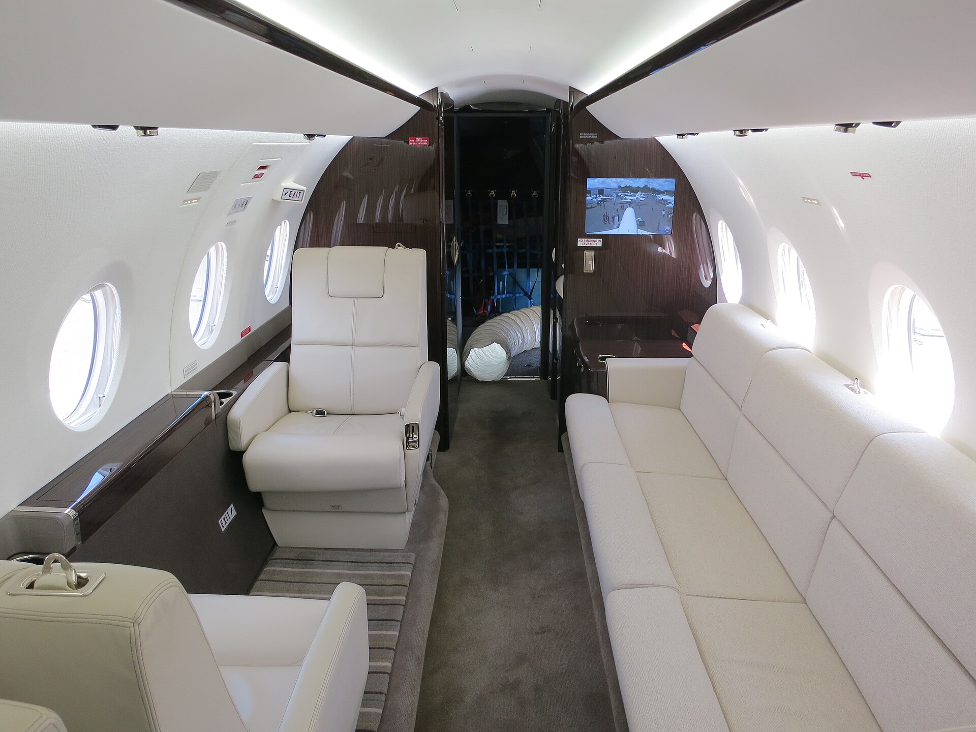 Inside a private jet cabin with cream leather seating